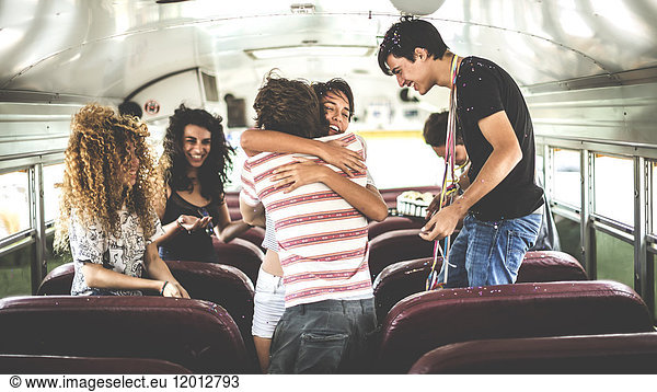 A group of young people in a party on a school bus.