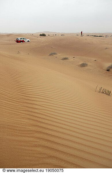 A guide and jeep on top of sand dunes in the empty quarter near Dubai