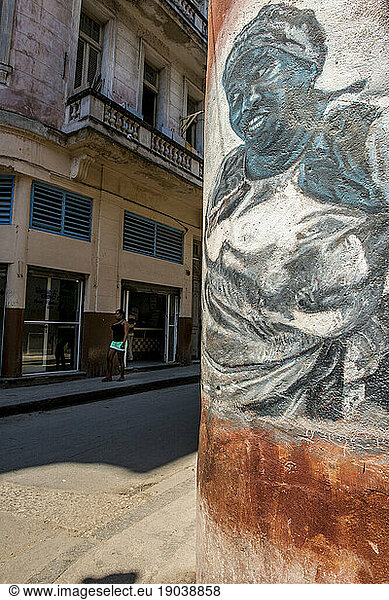 A hand-painted mural of an afro-cuban woman wearing a bandana and cooking apron  looking down at the street corner. Old Havana  La Habana  Cuba.