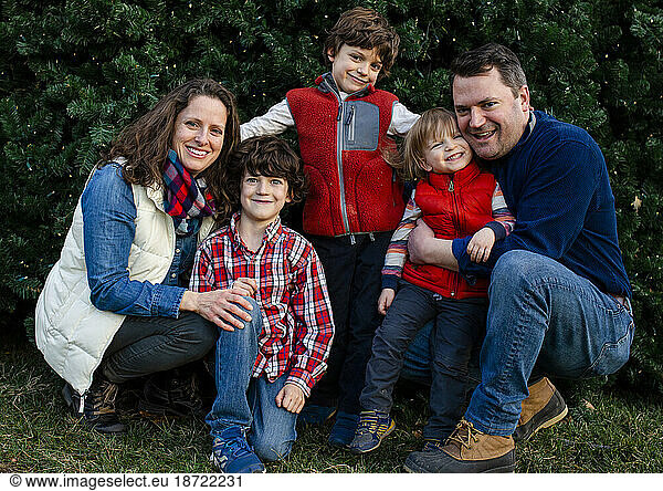 A happy family snuggle together for a family portrait outside