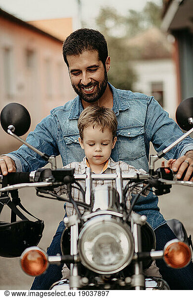 A happy father with his son drives a motorcycle