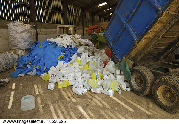 A heap of plastic recycling  waste piled up beside a trailer.