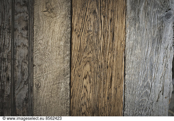 A heap of recycled reclaimed timber planks of wood. Environmentally responsible reclamation in a timber yard. Varieties of wood  with grain and colour details.