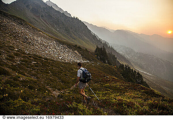 A hiker climbs Glacier Peak in the early morning light in Washington.