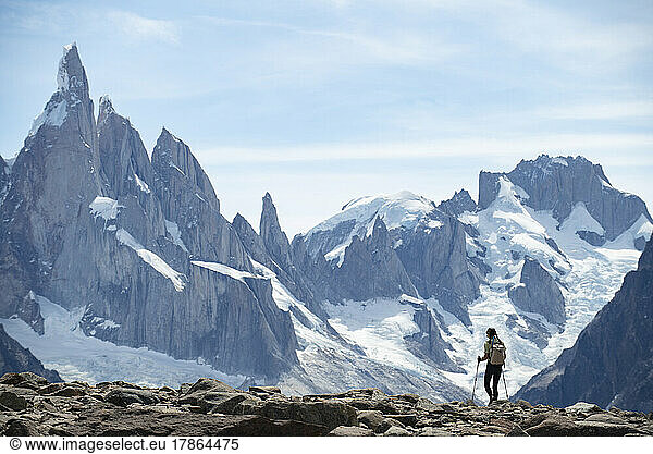 A hiker silhouetted against the massive peaks of Cerro Torre