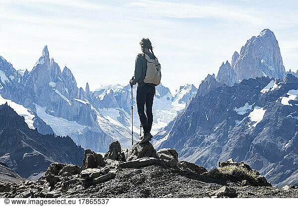 A hiker silhouetted against the massive peaks of Cerro Torre