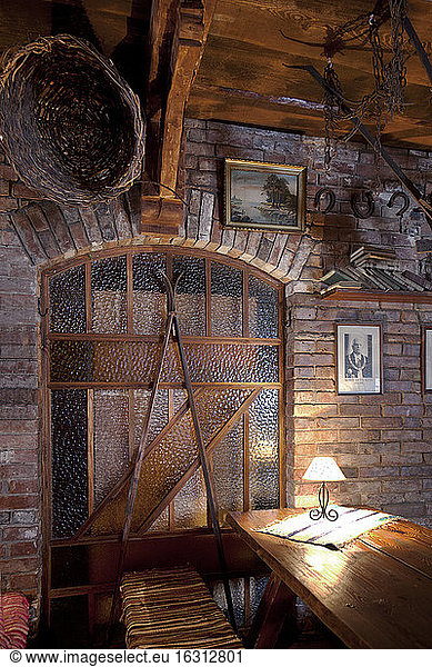 A hotel with old fashioned retro styled rooms  and rustic objects  staine glass  exposed brick and old photographs.