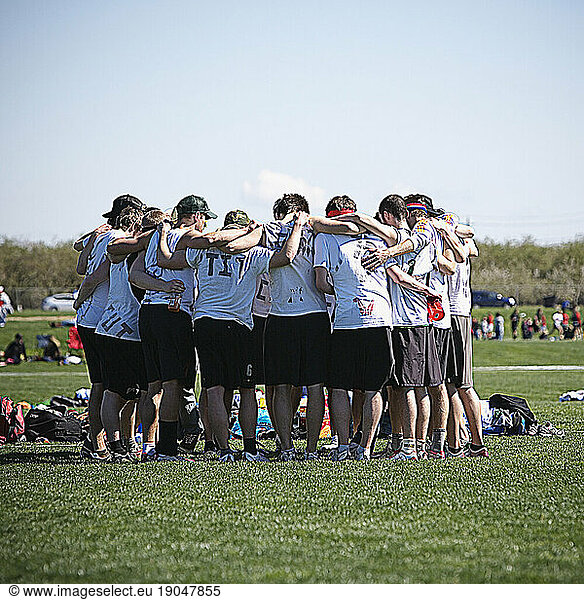 A huddle of young frisbee players. Photo manipulated.