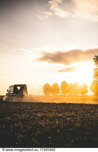 A jeep drives offroad in a field