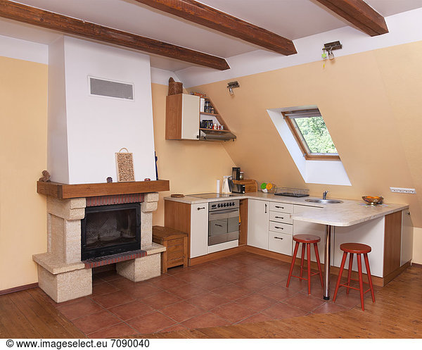A kitchen corner of a living room. Open plan living. Skylight and chimney.
