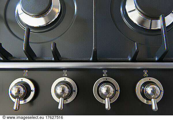 A kitchen stove with gas burners and control knobs.