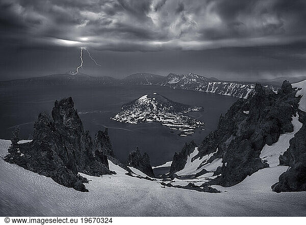 A lightning strike over the skyline of Oregon's Crater Lake adds emphasis to a dramatic and stormy scene.