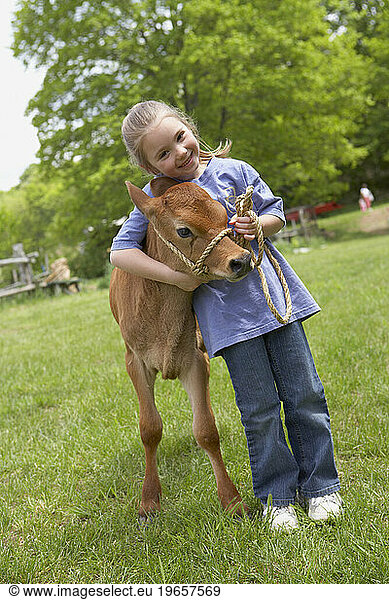 A little girl hugging a baby cow at a farm in Madison  CT.