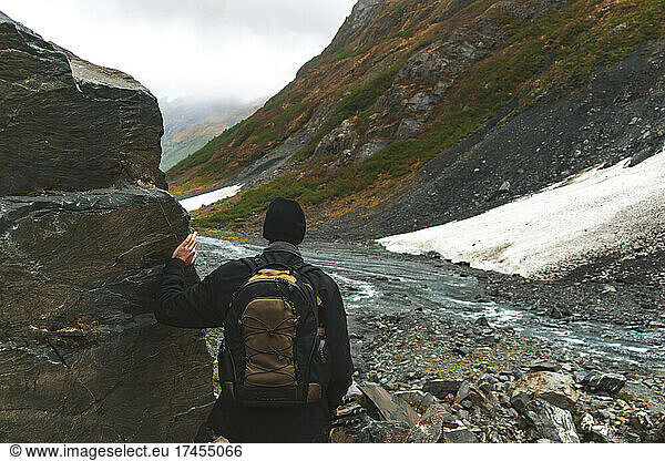 A lone man hikes the boulder fields of Byron Glacier in Alaska