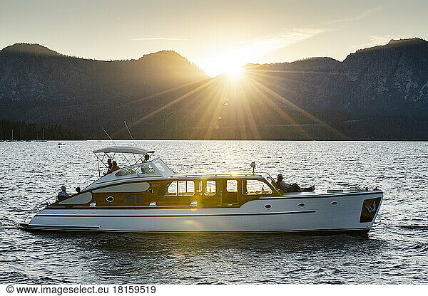 A luxurious yacht cruises during sunset.