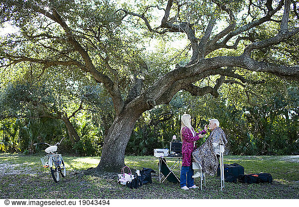 A makeup stylist works on a man during location production in Florida.