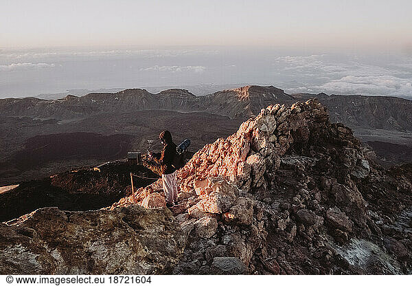 A male hiker watches sunrise from summit of El Teide