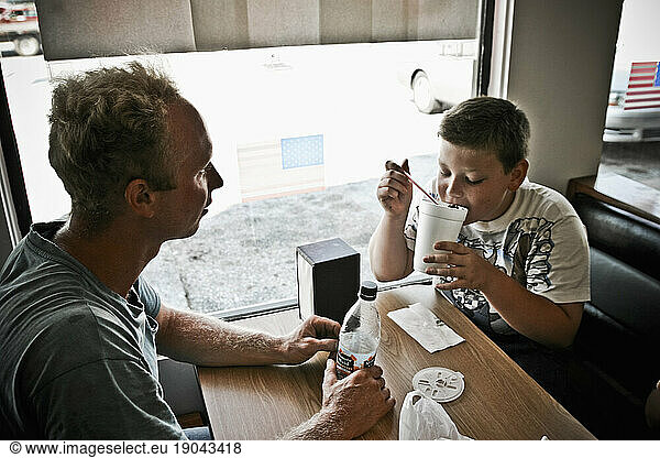 A man and his nephew enjoy a milkshake at a local grocery store near their family's dairy farm in Keymar  Maryland.
