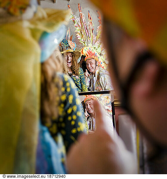 A man and woman check their costumes before a parade in Santa Barbara. The parade features extravagant floats.