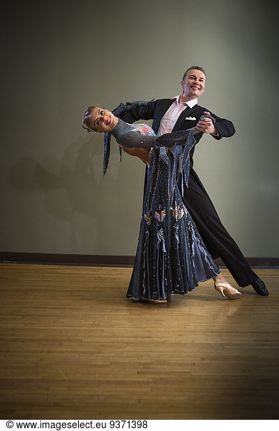 A man and woman dancing together in a dance studio.