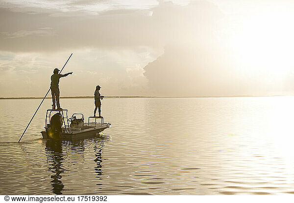 A man and woman fly fishing on a flats boat in the Florida Keys