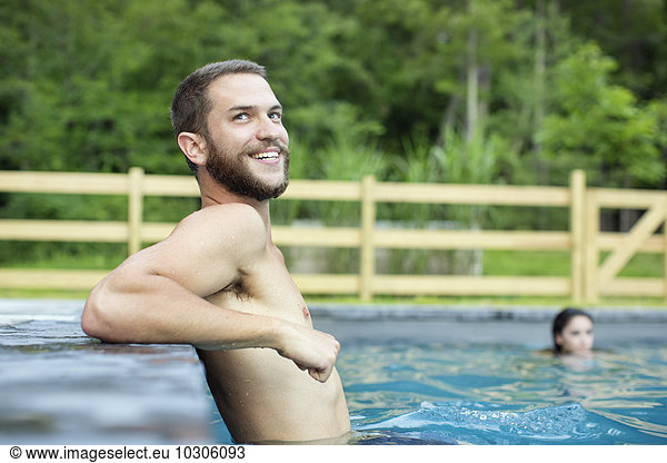 A man and woman swimming in a lake or pool.