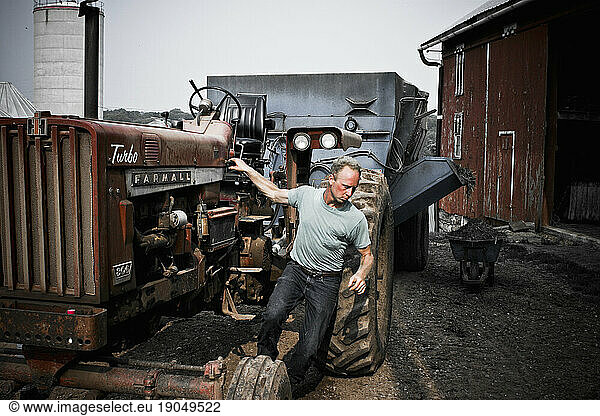 A man climbs down from the tractor at his family's dairy farm in Keymar  Maryland.