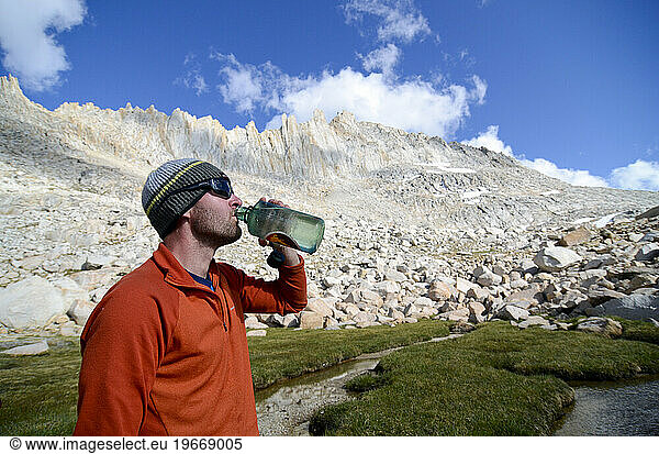 A man drinks from his water bottle below Feather Peak on the Sierra High Route  CA.