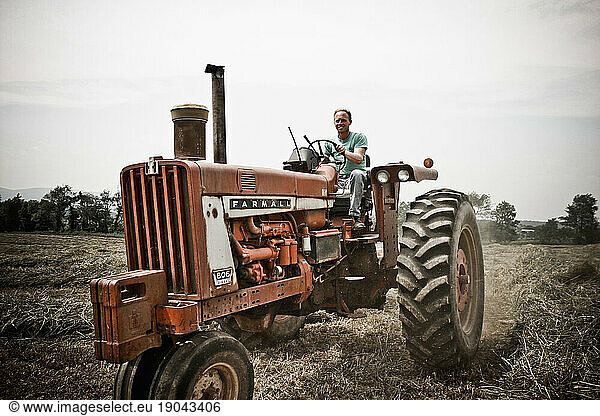 A man drives his tractor through a field at his family's dairy farm in Keymar  Maryland.