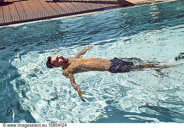 A man floating in a pool.