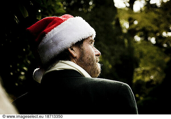 A man in a santa hat walks through Muir Woods in California.