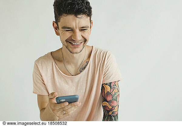 a man in a T-shirt with a phone in his hands