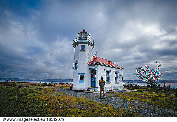 A man is standing near a historical lighthouse at Vashon island
