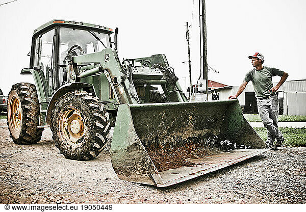 A man leans on a tractor waiting on his family's dairy farm in Keymar  Maryland.