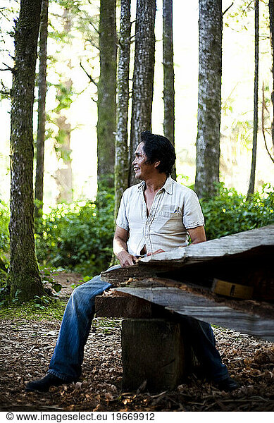 A man native to the West Coast of Vancouver Island carves a canoe as his tribes have for centuries.