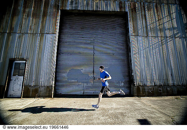 A man out on an early morning run in the industrial parts of the city.