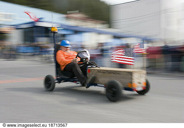 A man races his fancy soap box racer  4th of July celebrations  Cordova  Alaska.