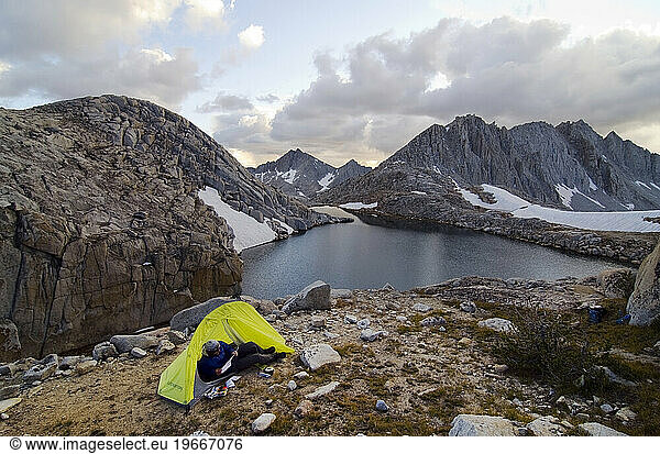 A man relaxes in his tent next to White Bear Lake on the Sierra High Route  CA.