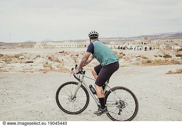 A man riding his adventure bike in a desert village in Tenerife
