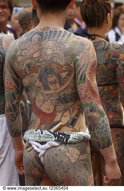 A man showing his full body tattooed  possibly a member of the Japanese mafia or Yakuza  attends the Sanja Matsuri in Asakusa district on May 20  2018  Tokyo  Japan. The Sanja Matsuri is one of the largest Shinto festivals in Tokyo  and it is held in Tokyo's Asakusa district for three days around the third weekend of May. Large groups of people dressed up traditional clothes carry Mikoshi (sacred portable shrines) between the streets near to Sensoji Temple to bring blessing and fortune to the inhabitants of the neighboring community at Asakusa during the second and third day of the festival. The annual festival attracts millions of visitors every year.