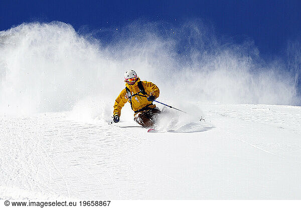 A man skiing on a bluebird powder day at a mountain resort near South Lake Tahoe  California.