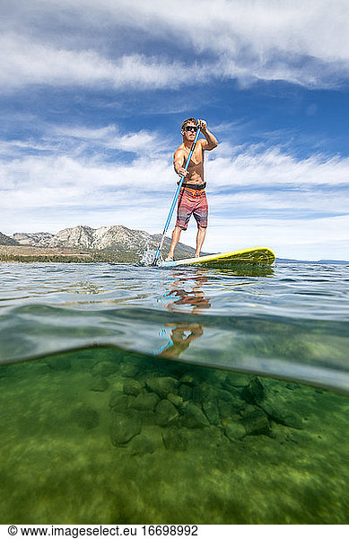 A man stand up paddle boarding on Lake Tahoe  CA