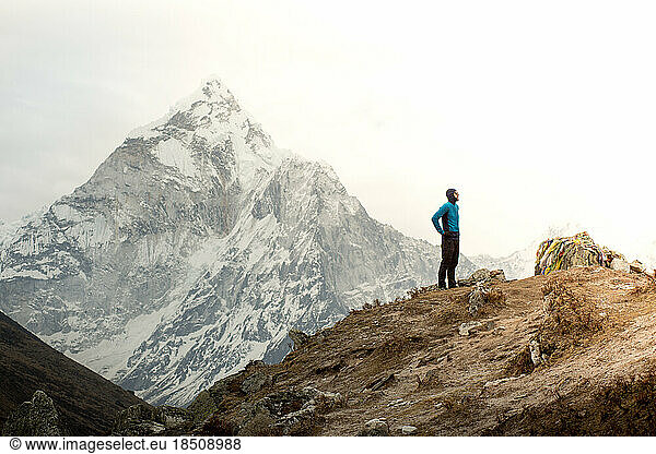 A man stands in front of Ama Dablam at the Everest Memorial Park.