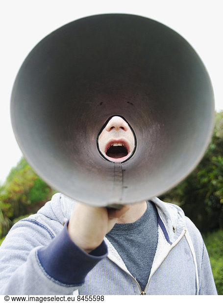 A man using a megaphone in the open air.