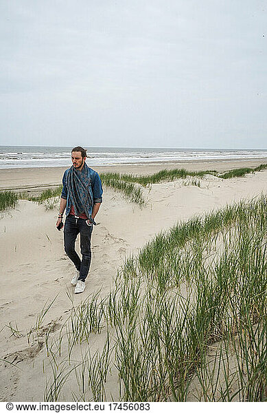 A man walking by himself on the sandy beach  Zeeland  Netherlands