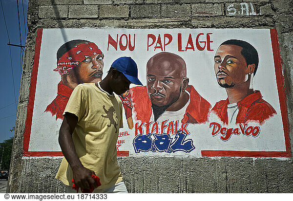 A man walks past a mural dedicated to the deceased members of the rap kreyol group Barikad Crew  in Port-au-Prince  Haiti.
