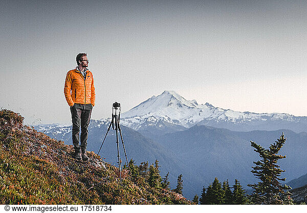 A man with a camera is standing in North Cascades near mt. Baker