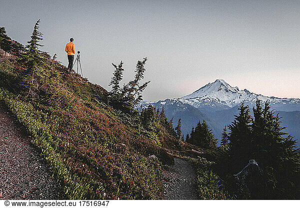 A man with a camera is taking pictures of mountains in North Cascades