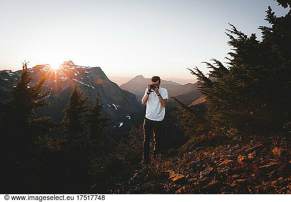 A man with a camera is taking pictures of mountains in North Cascades
