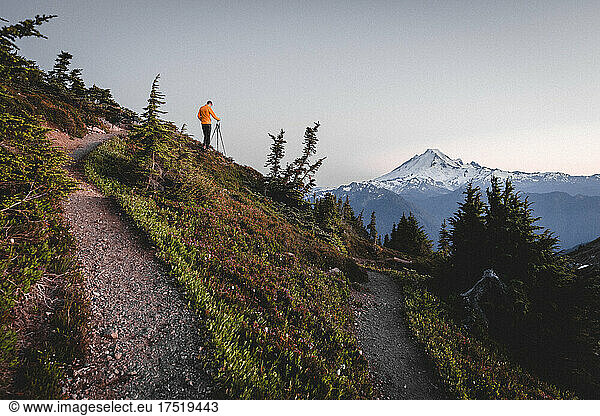 A man with a camera is taking pictures of mountains in North Cascades